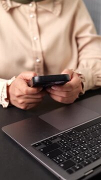 Vertical video, Woman using smartphone at home. She Is typing while using phone. Video shows hands close up.