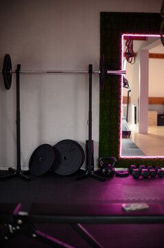 Modern gym interior with weightlifting equipment and neon lighting
