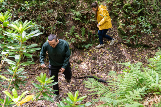 Couple trekking muddy forest path enjoying nature adventure