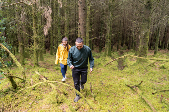 Couple hiking through a mossy forest exploring nature