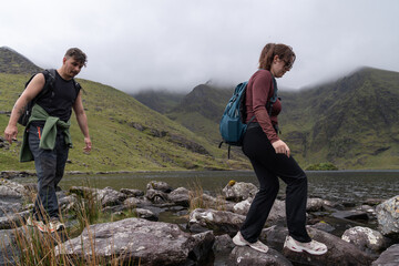 People hiking stepping stones across lake in kerry ireland © Cavan