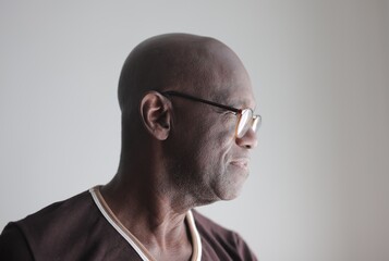 Profile portrait of a senior bald Black man wearing glasses © Cavan