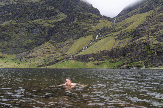 Man wild swimming in a cold mountain lake