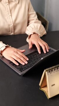 Close up female hands typing on computer sitting in the office. Young woman working on laptop at home while eating healthy salad for dinner at home. Technology lifestyle concept.