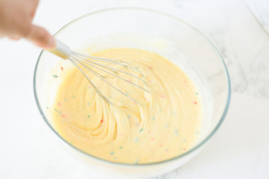 Hand mixing colorful sprinkle cake batter