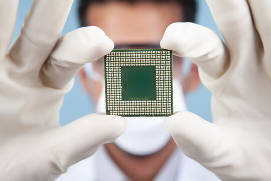 Scientist holding microchip or computer processor close up in a clean lab