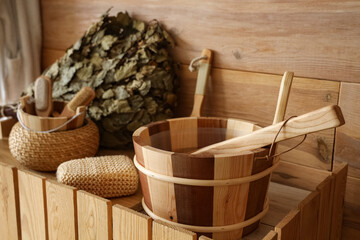 Obraz premium Bucket of water with loofah on counter in sauna, closeup