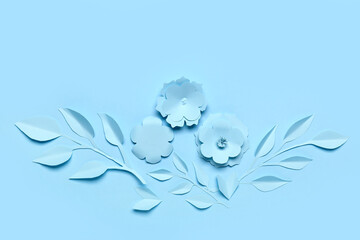 Light blue paper flowers and leaves arrangement on solid background for craft projects and...