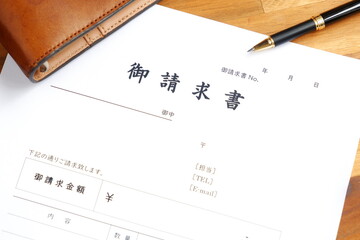 請求書 - 取引先へ宛てて請求書を準備する、ビジネスシーンのイメージ  © PJM