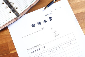 請求書 - 取引先へ宛てて請求書を準備する、ビジネスシーンのイメージ  © PJM