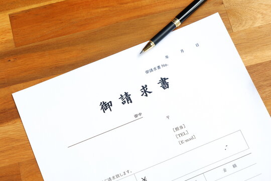 請求書 - 取引先へ宛てて請求書を準備する、ビジネスシーンのイメージ
