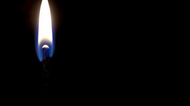 A match is lit and burns with fire on a black background, the match burns out