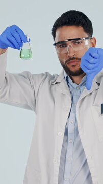 Science, face and man with liquid and thumbs down, disappointed and experiment fail for lab study. Portrait, pharmaceutical and medical scientist with beaker, mistake or research on studio background