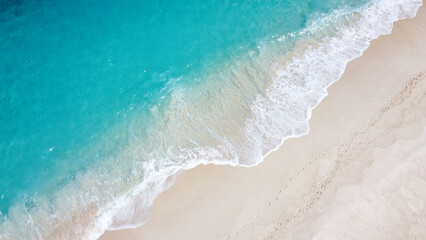 Aerial birdseye view of remote exotic tropical island with white frothy waves, sandy beach, and turquoise ocean water in paradise © Travelanza