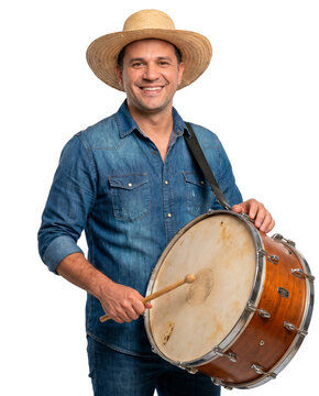 Portrait of a smiling man in a straw hat and denim shirt playing a traditional drum