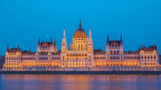 Stunning view of illuminated Hungarian Parliament Building reflecting in the Danube River at dusk