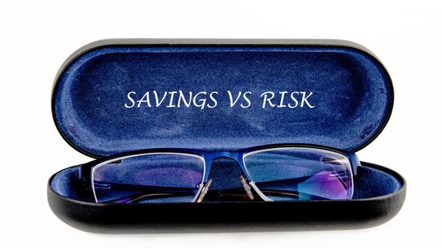 A close-up view of glasses in a case with the words savings vs risk. It looks at how these factors affect money choices and investments