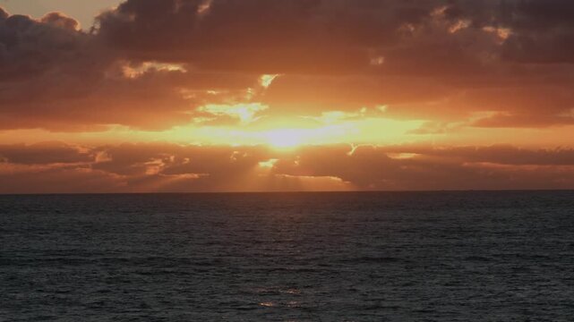 Static shot of a dramatic golden sunset over the calm Atlantic Ocean at Labenne-Ocean, Landes, France