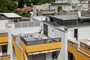 Obraz premium Modern residential building rooftops with outdoor terraces and balconies, urban architecture and lifestyle