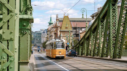 Beautiful tram crossing the green bridge in Budapest, Hungary during a sunny day