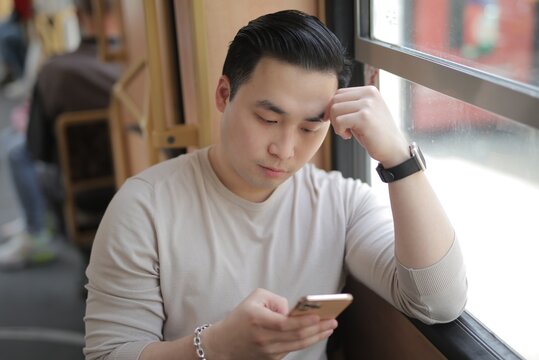 Stressed man using smartphone on public transport