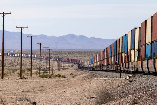 A long double stack container train travels through the desert