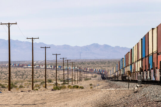 A long cargo train winds through an arid landscape