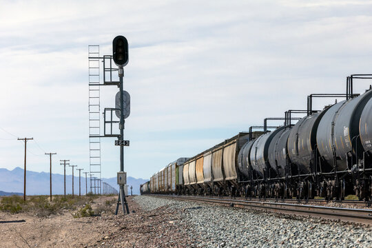 A long freight train on tracks in the desert