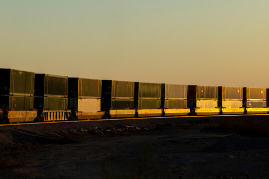 Freight train carrying containers during golden hour