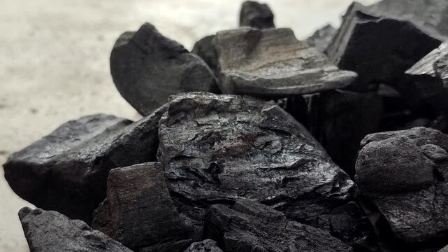 A collection of charcoal. Charcoal is a black, carbonaceous residue produced by burning wood without oxygen (pyrolysis). This material is widely used as a cooking fuel