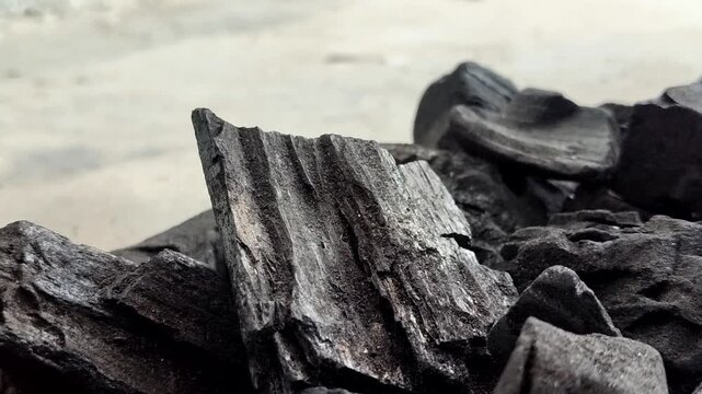 A collection of charcoal. Charcoal is a black, carbonaceous residue produced by burning wood without oxygen (pyrolysis). This material is widely used as a cooking fuel