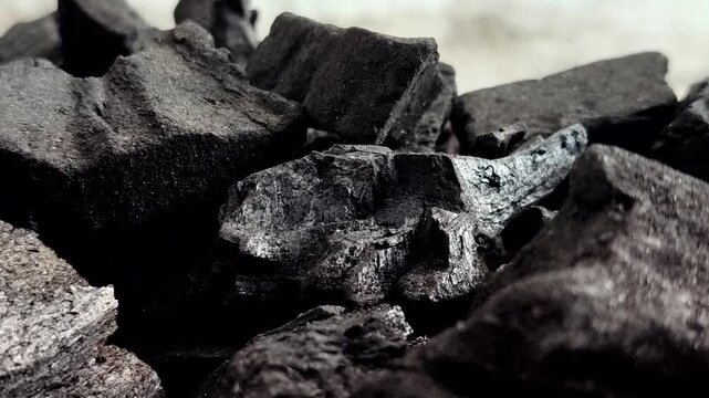 A collection of charcoal. Charcoal is a black, carbonaceous residue produced by burning wood without oxygen (pyrolysis). This material is widely used as a cooking fuel