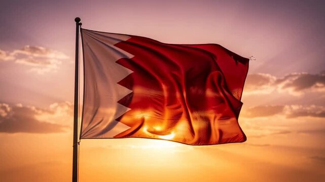National flag of Qatar waving against a golden sunset sky