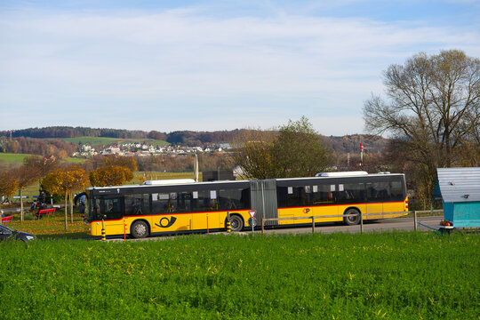 Scenic rural landscape with with yellow Swiss Post bus passing at Swiss village of Oberglatt on an autumn day. Photo taken November 11th, 2025, Zurich Oberglatt, Switzerland.