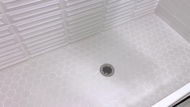 White tiled shower floor with hexagon pattern