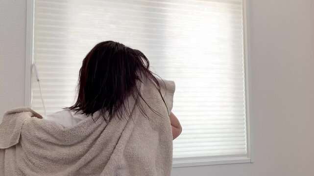 濡れた髪をタオルで拭く女性