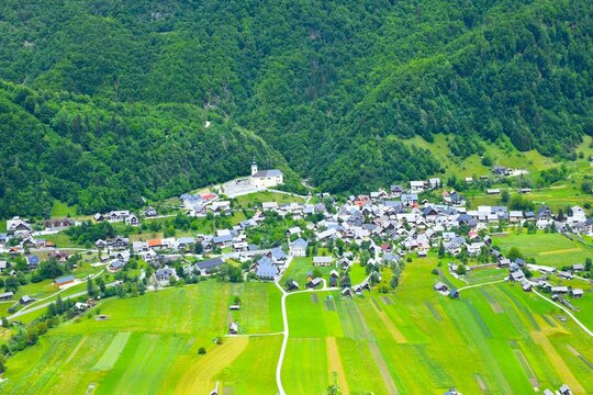 Aerial view of Srednja vas village near Bohinj with green fields and forest above in Gorenjska, Slovenia