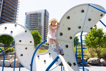 Young girl climbing modern playground structure © VolodymyrNadtochii