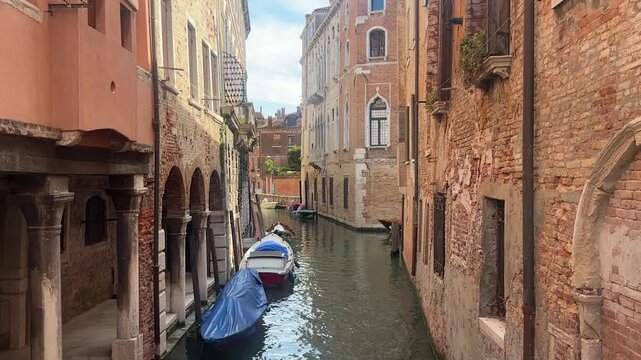 Beautiful still footage capturing the timeless charm of a Venetian canal, framed by historic architecture and reflected in the calm waters of one of the world's most iconic cities, Italy.