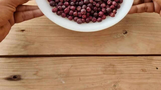 Phalsa berries served in white plate on wooden table during summer