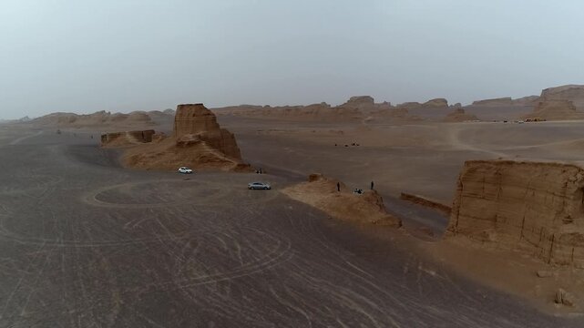 Final wide yardang field stretches to horizon under hazy sky with wind erosion creating epic natural desert landscape vista perfect for geology and wilderness stock video footage.