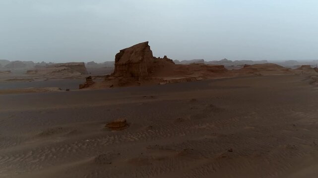 Yardang rocks with road in foreground create contrast in desert under clear sky with wind erosion patterns ideal for geology and travel stock video content.