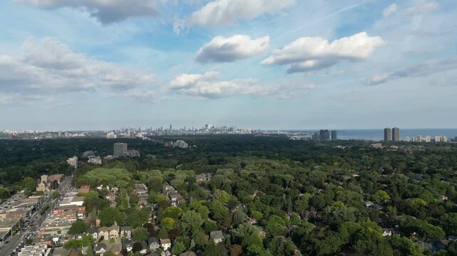 Aerial view rising over Bloor Street West in the Kingsway neighborhood of Toronto, Ontario, Canada. Looking southeast towards the downtown core Toronto skyline, Mimico and Lake Ontario.