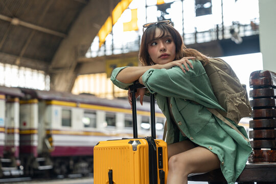 Young woman depressed mistakes a train. Female backpacker Traveler waiting at train station. Boarding the wrong ticket feeling stressed. Planning Fail trip tourist missing