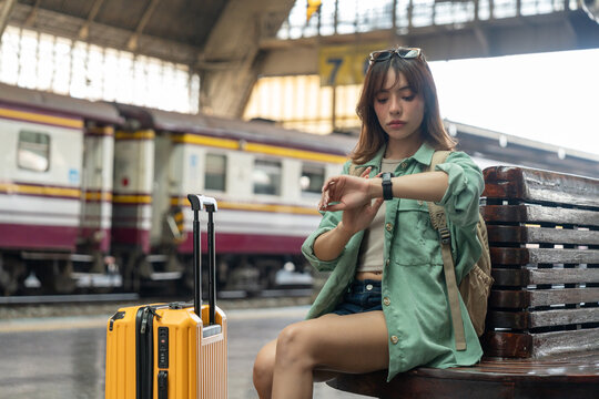 Young woman depressed mistakes a train. Female backpacker Traveler waiting at train station. Boarding the wrong ticket feeling stressed. Planning Fail trip tourist missing