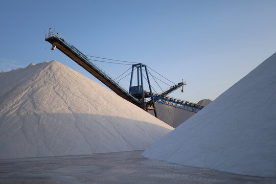 Salt Stacker Conveyor Between White Salt Mounds Alicante