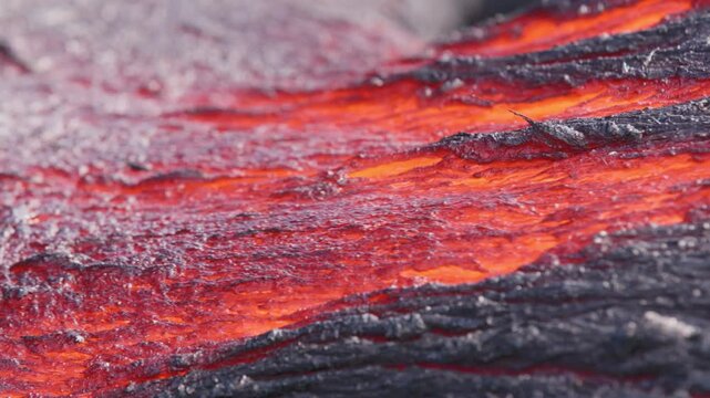 Extreme close-up of glowing lava flowing beneath a thin crust at Kīlauea Volcano, Hawaii. Molten magma creates vivid textures and patterns in an active lava flow.