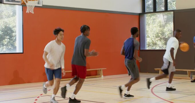 After layup rim bounce, diverse male friends rebounding ball, sprinting fast break on gym court