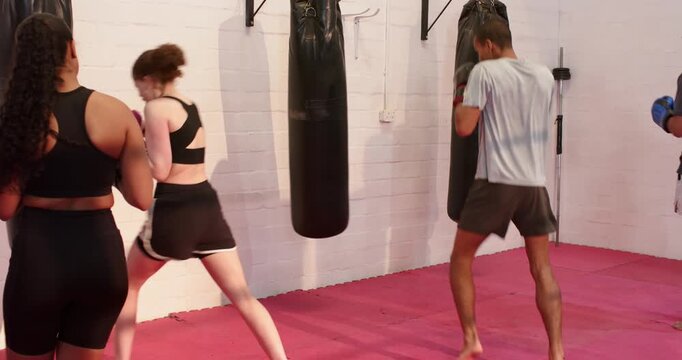 Diverse training partners preparing combos in gym at start until fourth partner joining on bags