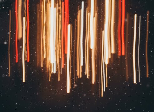 Abstract Vertical Light Streaks and Festive Bokeh Trails on Dark Background